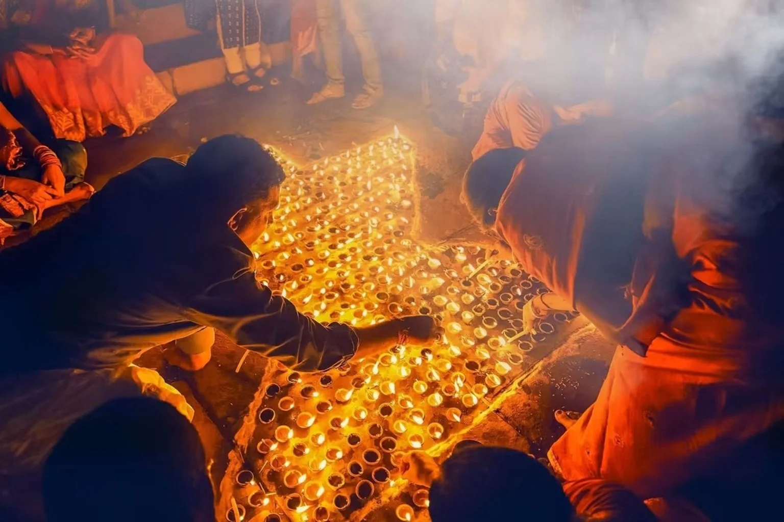 Lighting earthen lamps for Dev Deepawali