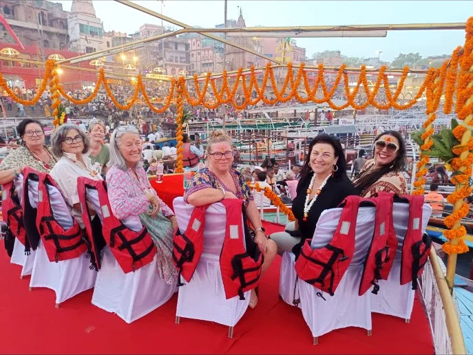 Travellers seated on a flower-decorated boat before the evening Ganga Aarti in Varanasi