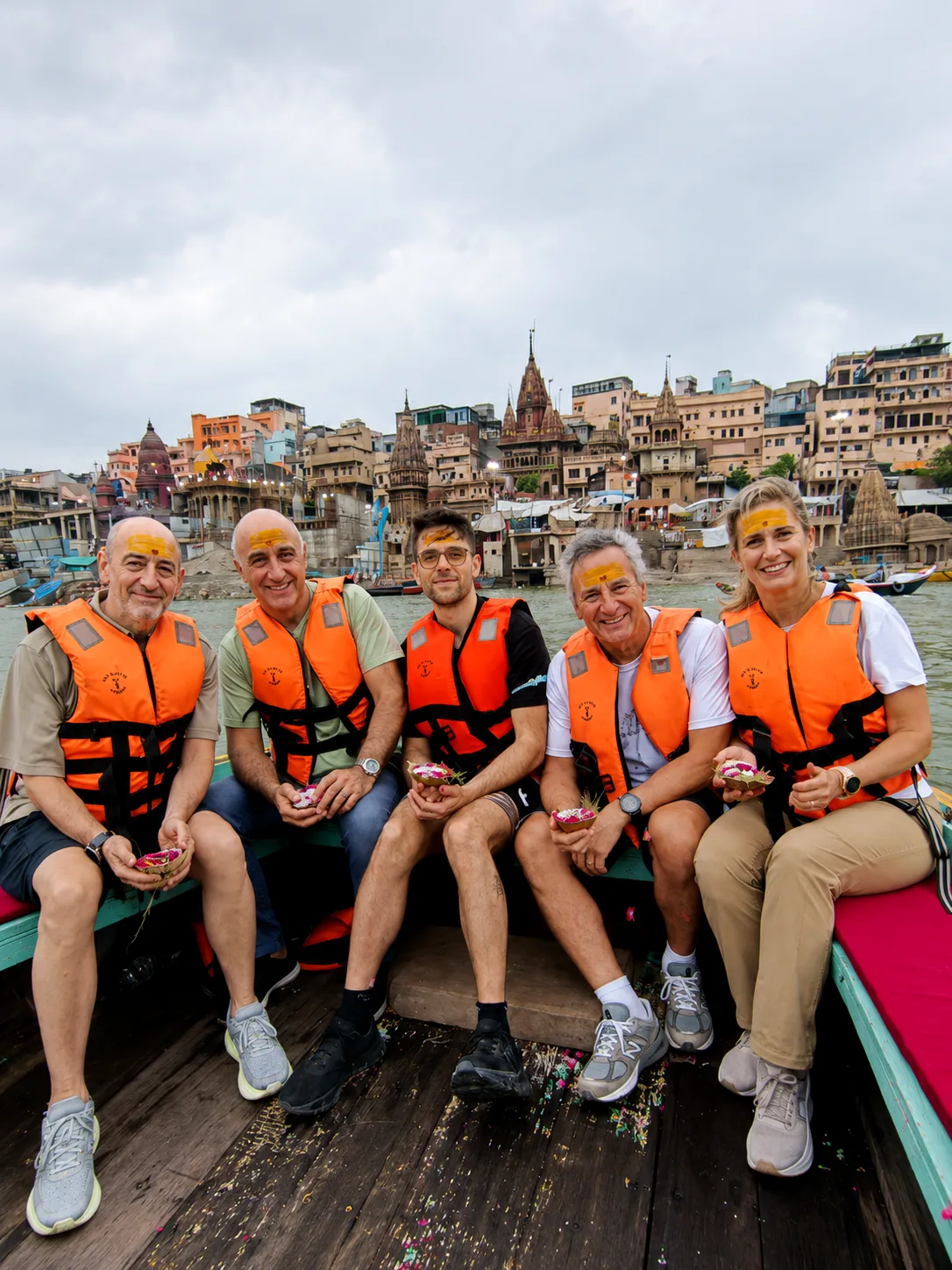 Travellers on a private Ganges boat ride with the historic ghats of Varanasi behind them