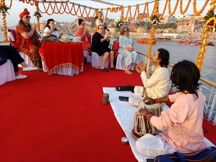 Guests listening to live Indian classical music on a decorated boat on the Ganges