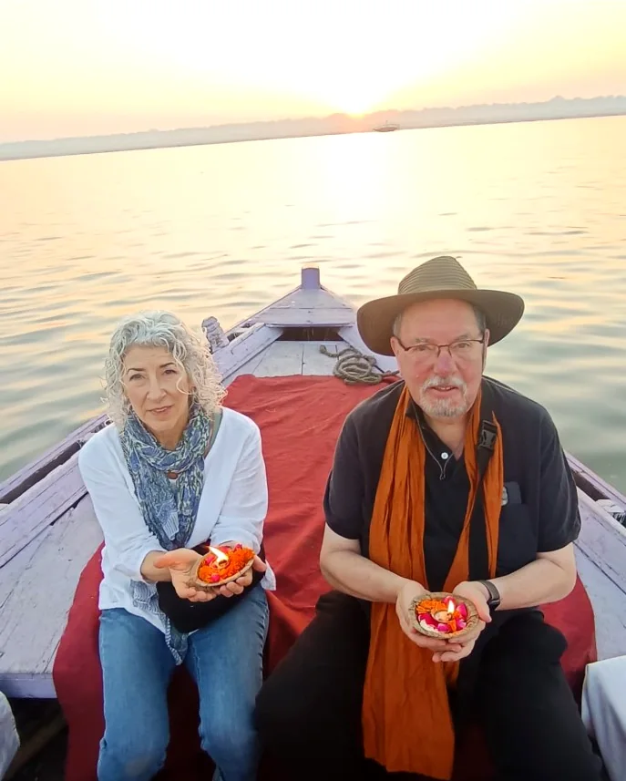 Couple holding flower lamps during a private sunrise boat experience on the Ganges