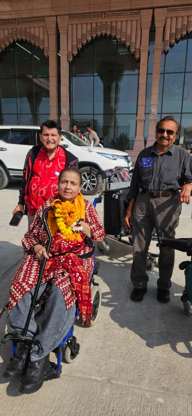 A guest using a wheelchair with accompanying people during a temple visit