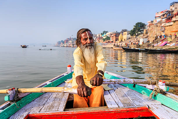 Local boatman and riverfront planning on the Ganges in Varanasi